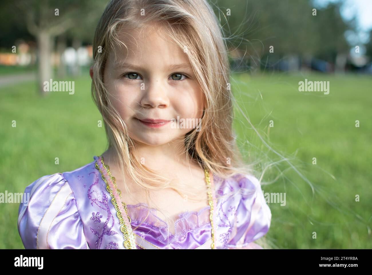 Portrait of a beautiful smiling little girl with a long blond hair ...