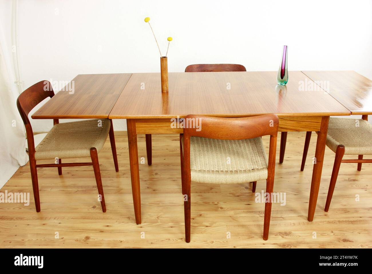 A Mid Century Teak Dining Table with four chairs from the 50s 60s Danish Design Vintage Dining solid wood Modern antique 50s 60s isolated on white wal Stock Photo