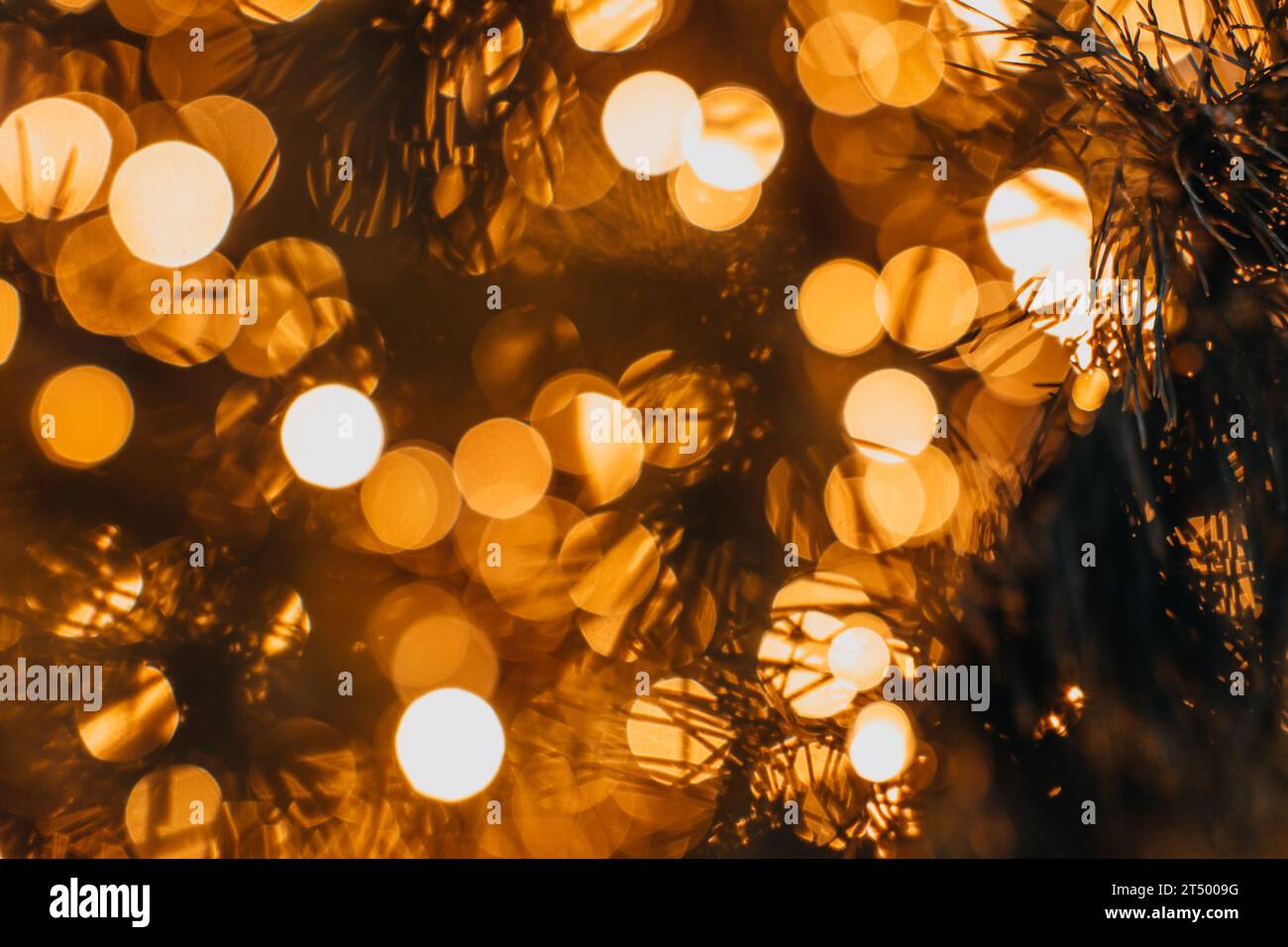 Christmas and New Year festive background. Golden magic glittering blurry bokeh lights of garland. Stock Photo