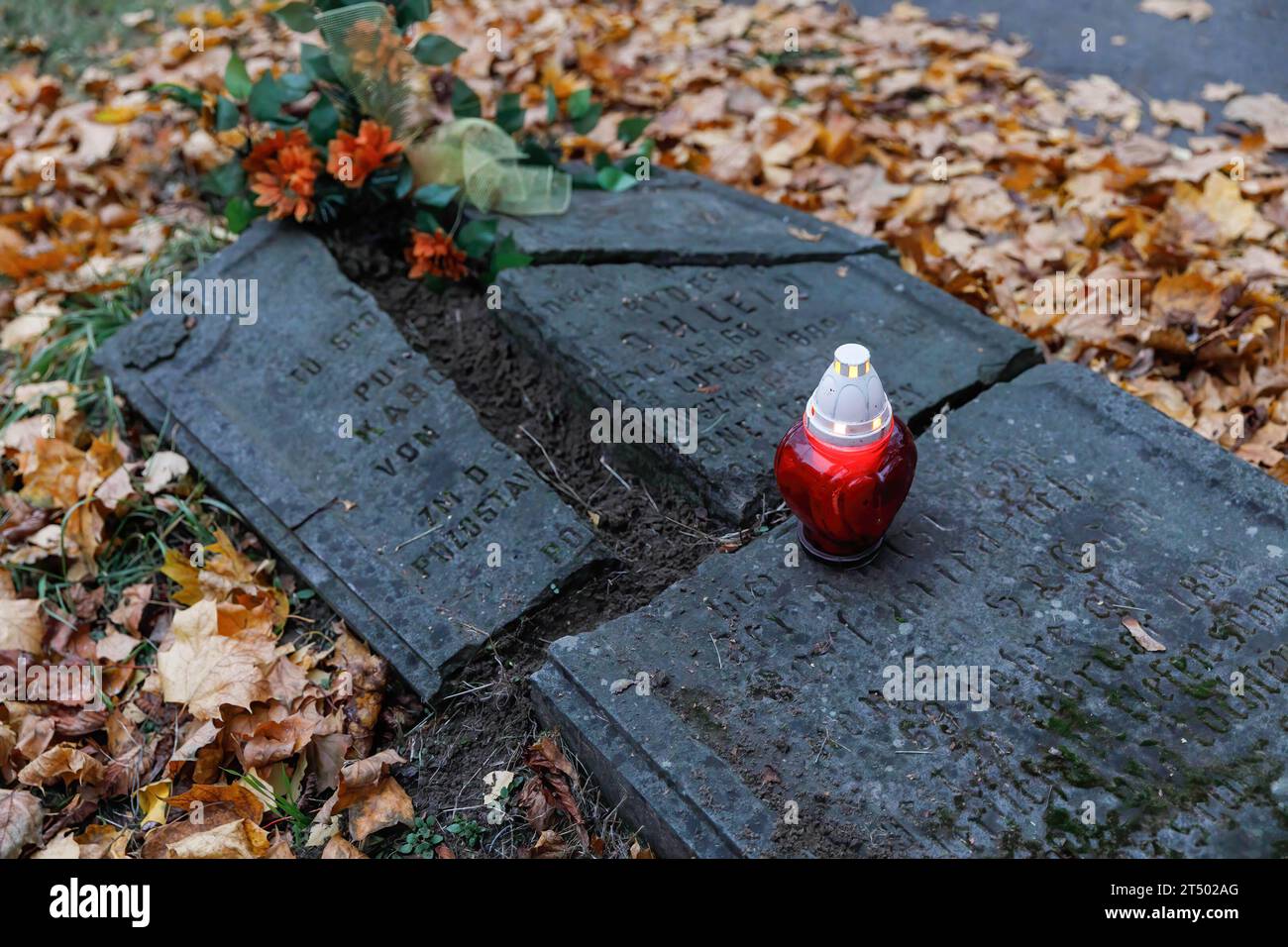 A candle in a lantern stands on a broken tombstone on All Saints' Day at the Evangelical-Augsburg Cemetery in Warsaw. All Saints' Day (or Dzie? Zaduszny in Polish) is a public holiday in Poland. It is an opportunity to remember deceased relatives. On this day, people bring flowers, typically chrysanthemums, and candles to cemeteries. The entire cemetery is filled with lights in the darkness. The Evangelical-Augsburg Cemetery is a historic Lutheran Protestant cemetery located in the western part of Warsaw. Since its opening in 1792, more than 100,000 people have been buried there. Stock Photo