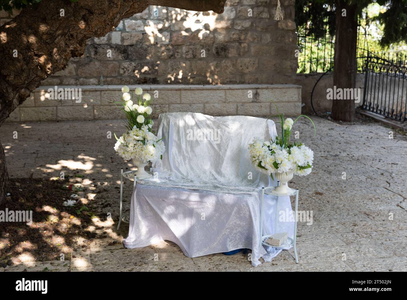 A decorative, wide chair laid out with linen and flowers for the bride