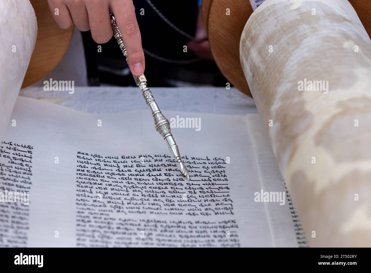 Prayer Script Scroll A reader uses a pointer to guide his eyes across the text of a Torah ...