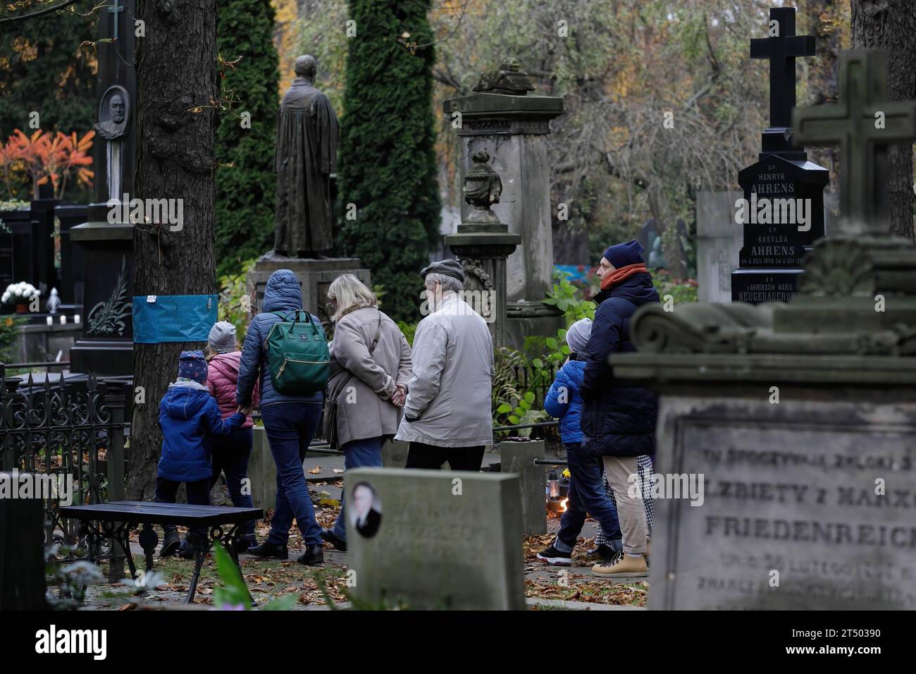 People take a walk through the cemetery on All Saints' Day at the Evangelical-Augsburg Cemetery in Warsaw. All Saints' Day (or Dzie? Zaduszny in Polish) is a public holiday in Poland. It is an opportunity to remember deceased relatives. On this day, people bring flowers, typically chrysanthemums, and candles to cemeteries. The entire cemetery is filled with lights in the darkness. The Evangelical-Augsburg Cemetery is a historic Lutheran Protestant cemetery located in the western part of Warsaw. Since its opening in 1792, more than 100,000 people have been buried there. (Photo by Volha Shukaila Stock Photo