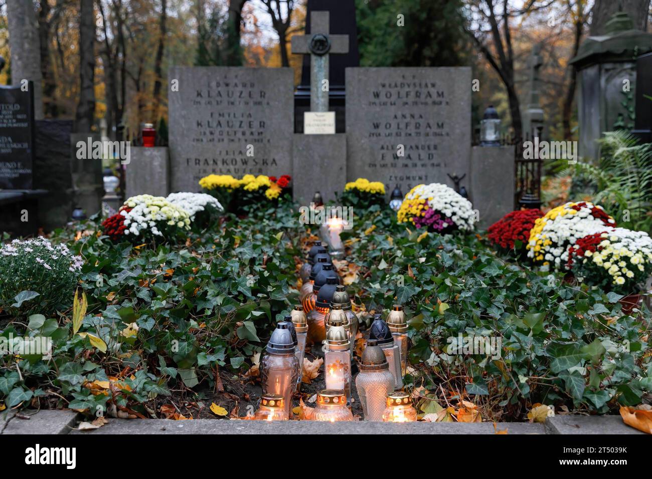 Flowers and lit candles stand on the grave on All Saints' Day at the Evangelical-Augsburg Cemetery in Warsaw. All Saints' Day (or Dzie? Zaduszny in Polish) is a public holiday in Poland. It is an opportunity to remember deceased relatives. On this day, people bring flowers, typically chrysanthemums, and candles to cemeteries. The entire cemetery is filled with lights in the darkness. The Evangelical-Augsburg Cemetery is a historic Lutheran Protestant cemetery located in the western part of Warsaw. Since its opening in 1792, more than 100,000 people have been buried there. (Photo by Volha Shuka Stock Photo