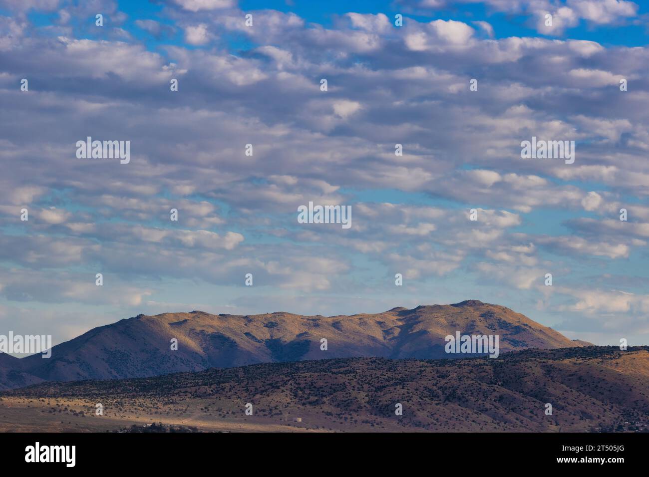 Clouds above the mountains in this landscape view from Stead Airport in Nevada. Stock Photo