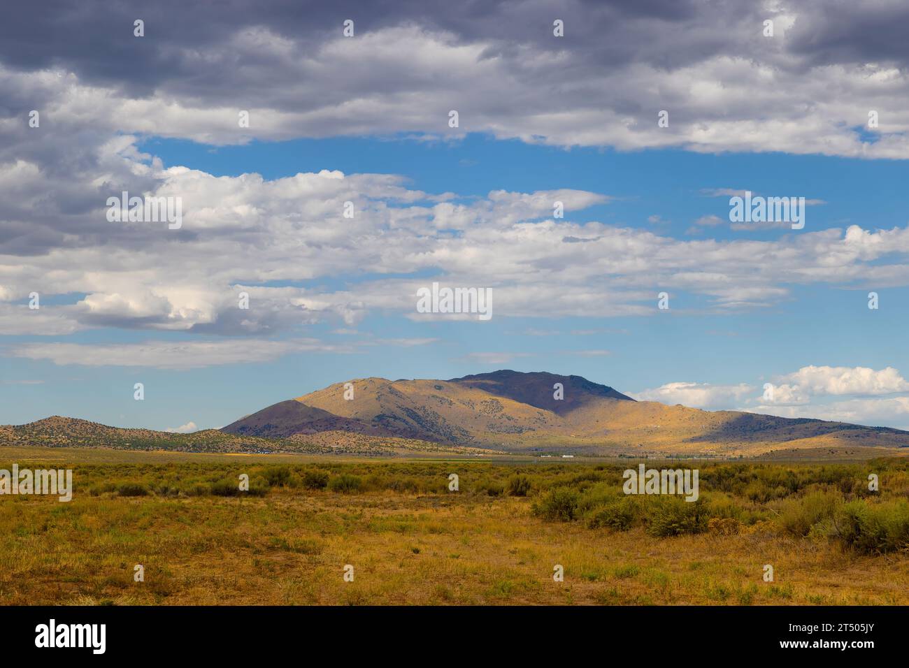 Clouds above the mountains in this landscape view from Stead Airport in Nevada. Stock Photo