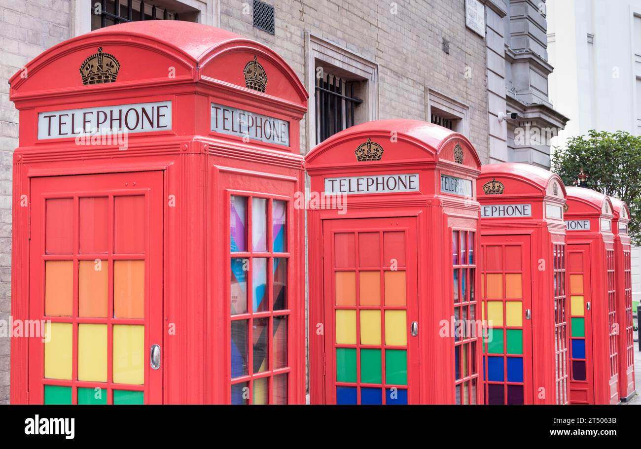 A row of classic K6 red phone boxes decorated with LGBTQ rainbow colours in Broad Court, Covent Garden, London, England, U.K. Stock Photo