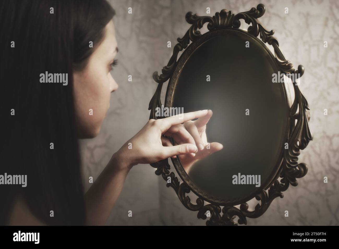 woman touches the reflection of herself in the mirror, abstract concept ...