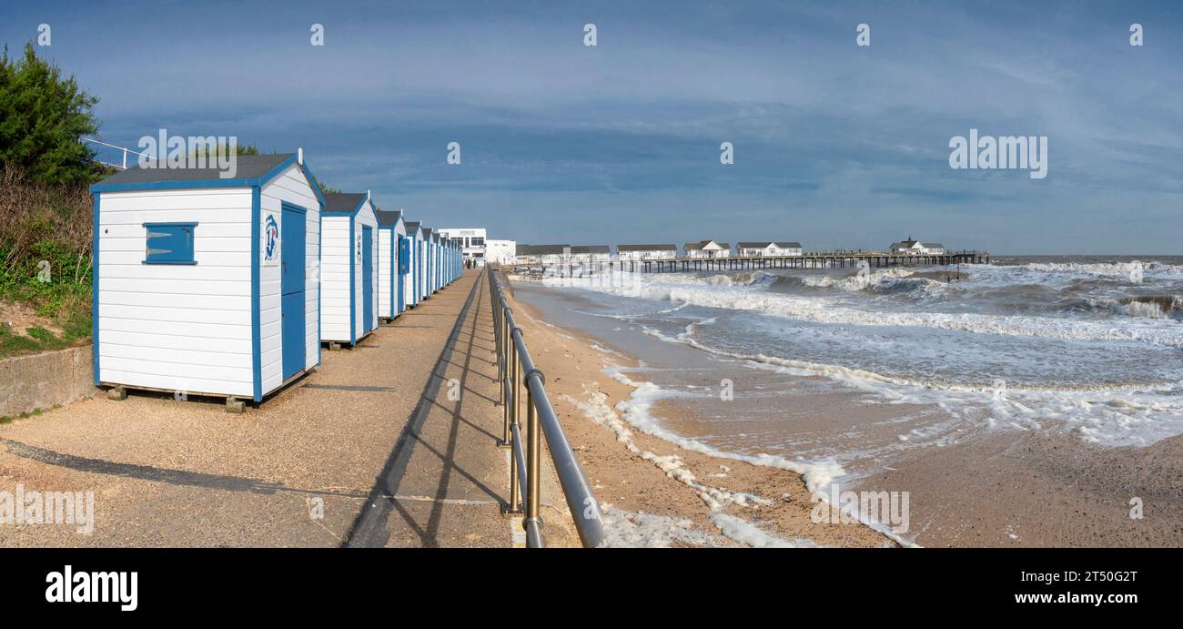 The image of Southwold promenade with its colourful beach huts looking towards Southwold Pier at the coastal resort town of Southwold in Suffolk Stock Photo