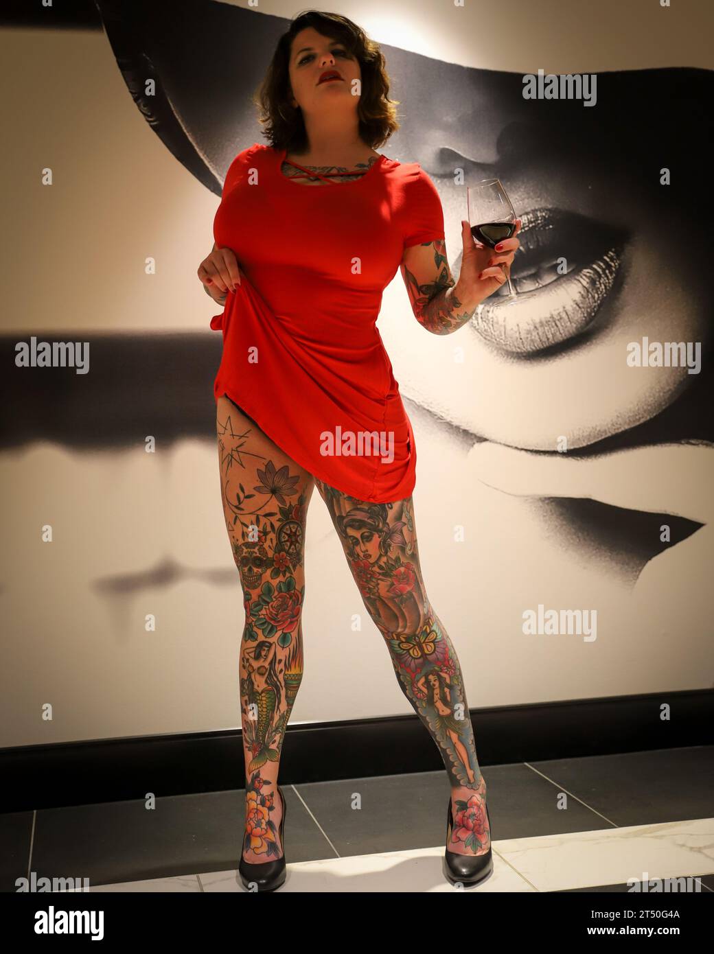 Heavily Tattooed Woman in Red Dress Stock Photo