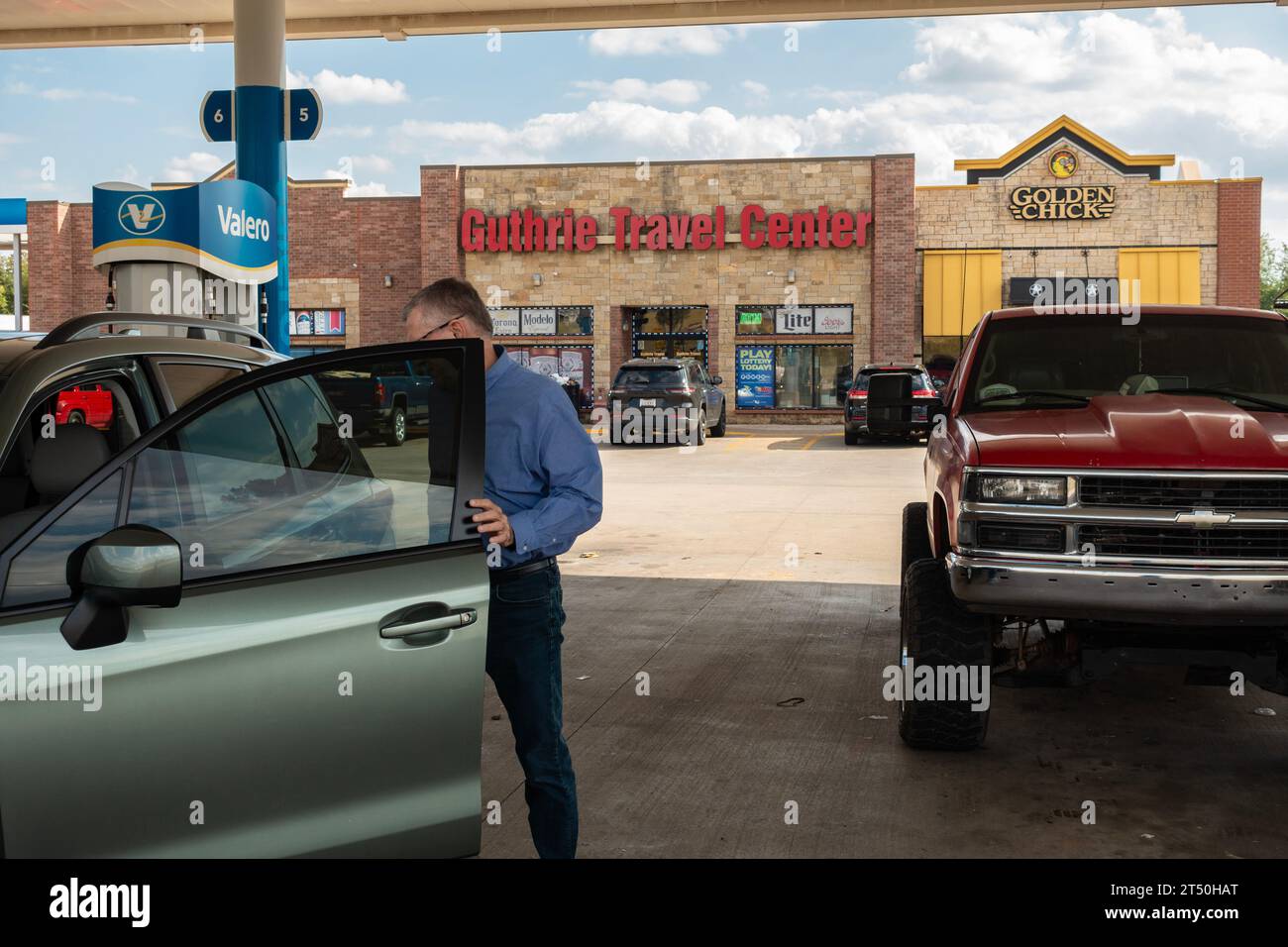 60 year old man enters his automobile after refueling at the Guthrie Travel Center in Guthrie, Oklahoma, USA Stock Photo