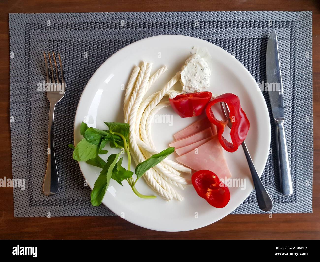 Turkish Helix String white Cheese with vegetables on plate with wooden background Stock Photo