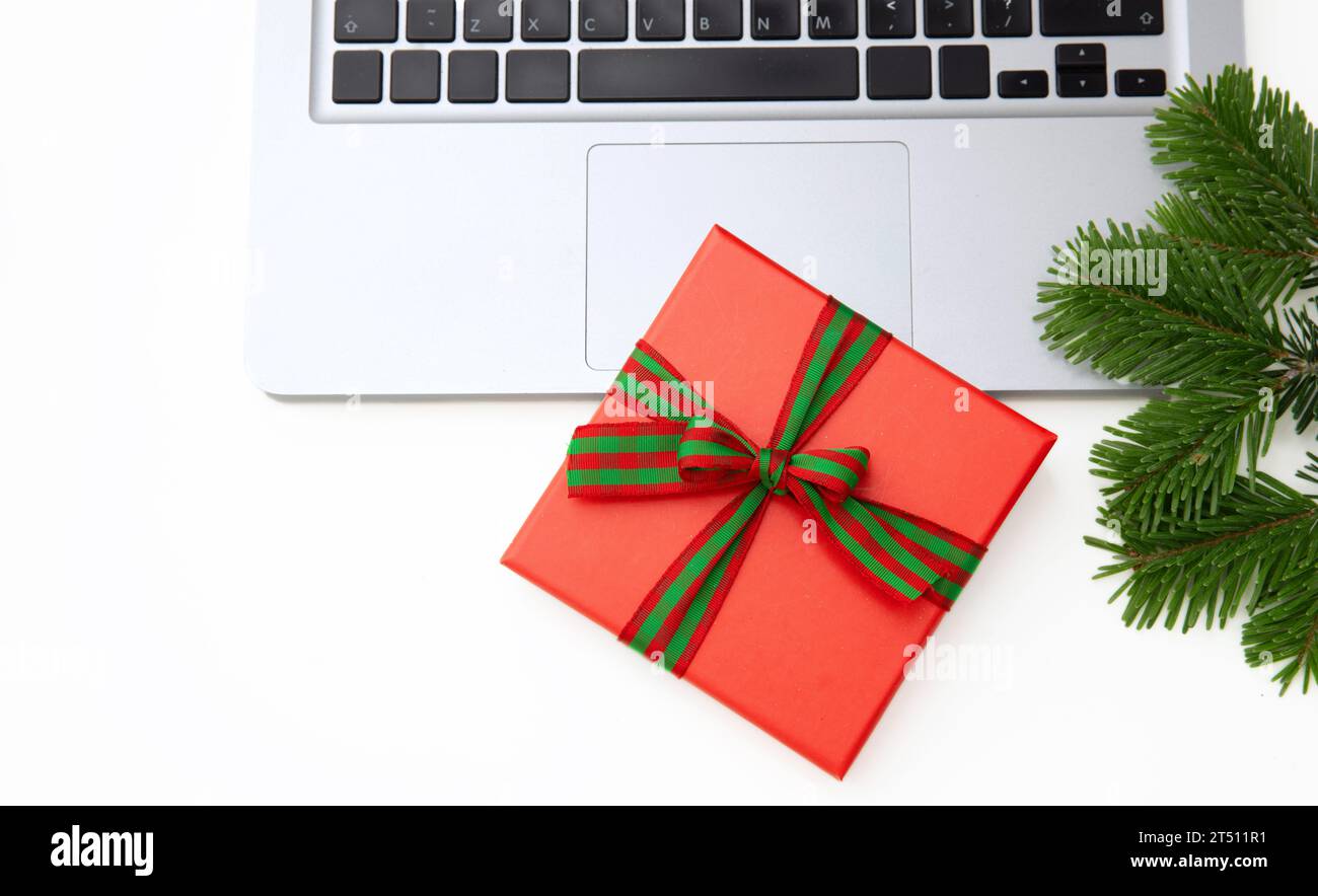 Red gift box and computer laptop isolated on white background, copy space Stock Photo