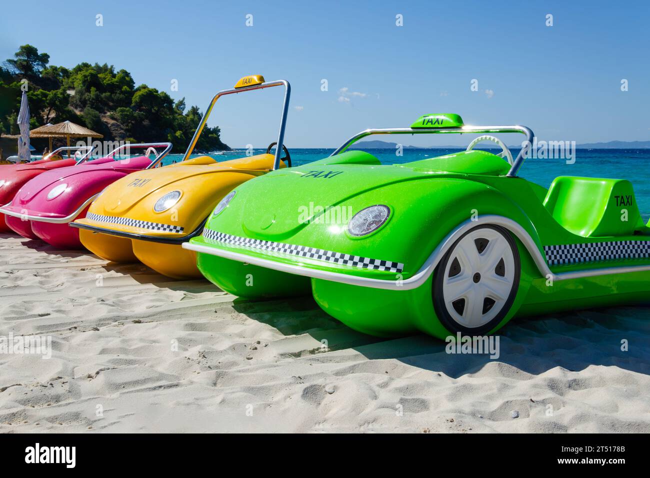 pedal catamarans in shape of  car lined up in  row. boats of different colors standing on sand Stock Photo