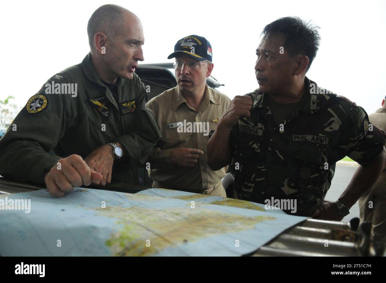 0806264009P-040 PHILIPPINES (June 26, 2008) Rear Adm. James P. Wisecup, commander, Carrier Strike Group (CSG) 7, center, Brig. Gen. Jorge Segovia, deputy assistant chief of staff for Operations of Armed Forces Philippines (AFP), right, and Capt. Thomas P. Lalor, deputy commander of Carrier Air Wing (CVW) 14, discuss the current relief efforts of the Nimitz-class aircraft carrier USS Ronald Reagan (CVN 76). At the request of the government of the Republic of the Philippines, Ronald Reagan is off the coast of Panay Island providing humanitarian assistance and disaster response in the wake of Typ Stock Photo
