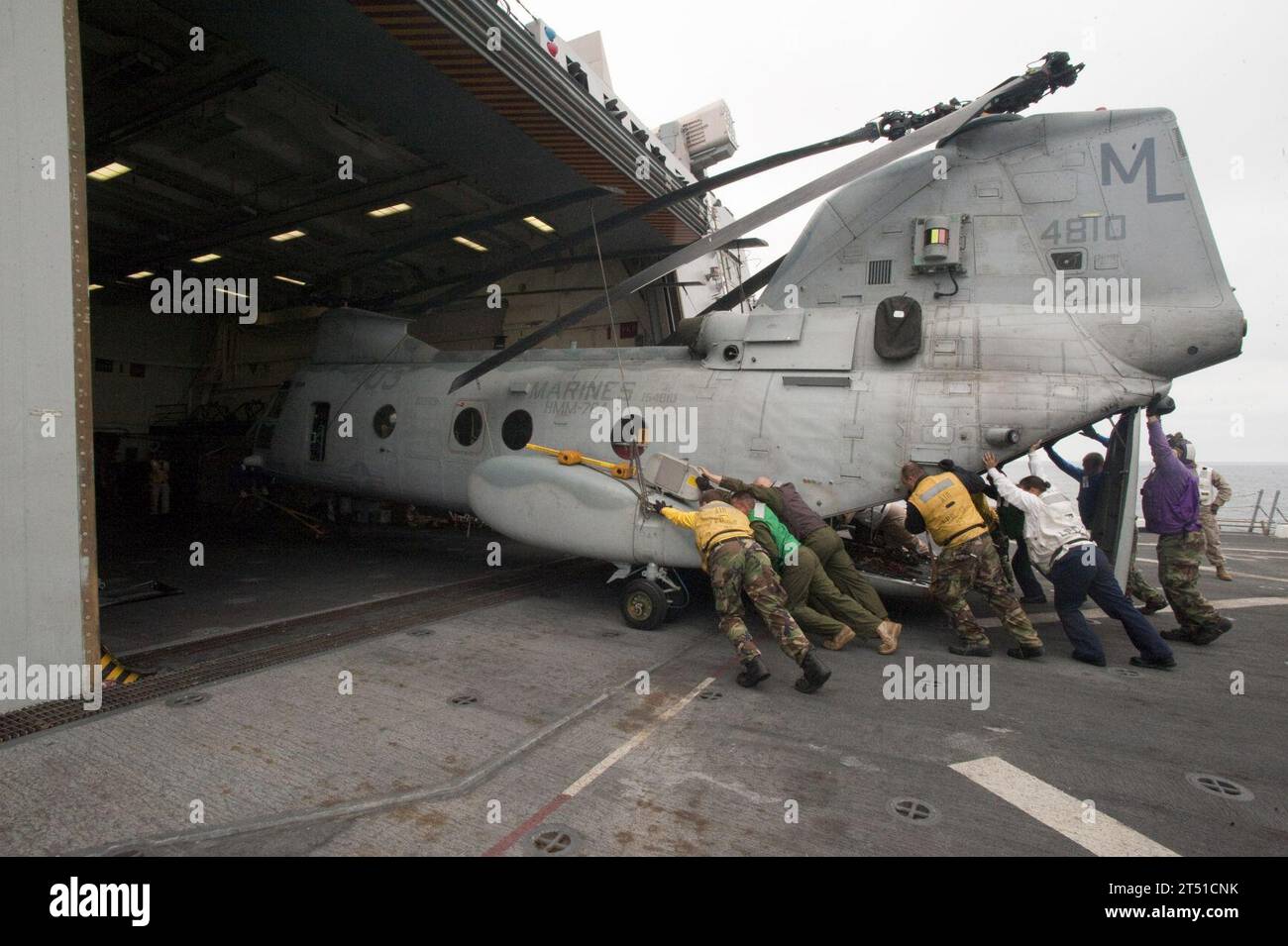1007015319A-034 PACIFIC OCEAN (July 1, 2010) Crew members push a Marine CH-46 Sea Knight helicopter into the hanger bay of the amphibious transport dock ship USS New Orleans (LPD 18) during Southern Partnership Station 2010. New Orleans is participating in Southern Partnership Station, an annual deployment of U.S. military training teams to the U.S. Southern Command area of responsibility. Navy Stock Photo