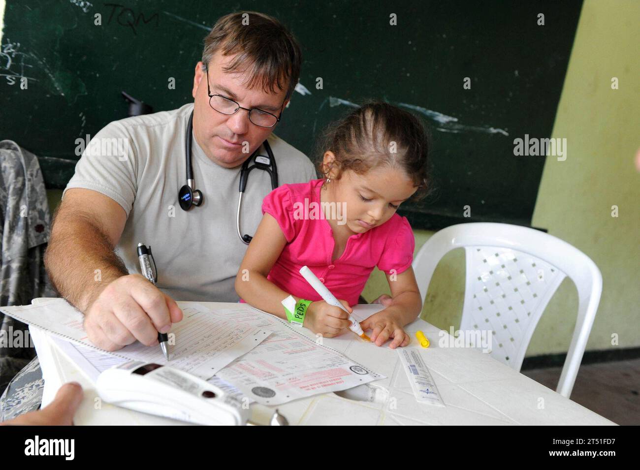 110609ET173-228 TUMACO, Colombia (June 9, 2011) Maj. Gary Ruesch, a nurse practitioner from Hill Air Force Base, Utah, completes medical forms as his patient draws a picture at the Escuela Max Seidel medical site in Tumaco, Colombia, during Continuing Promise 2011. Continuing Promise is a five-month humanitarian assistance mission to the Caribbean, Central and South America. (U.S. Air Force Stock Photo