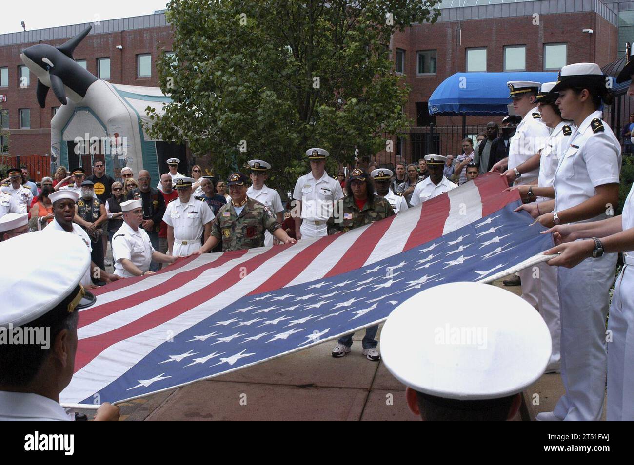 0807048154G-027 BOSTON (July 4, 2008) Sailors assigned to the multi-purpose amphibious assault ship USS Bataan (LHD 5) assist in the unfolding of a flag flown over the World Trade Center in New York City on September 11, 2001 during a ceremony at the U S. Coast Guard Station in Boston. Bataan is in Boston participating in the 27th annual Boston Harborfest, a six-day long Fourth of July festival showcasing the colonial and maritime heritage of the cradle of the American Revolution.  U.S. Navy Stock Photo