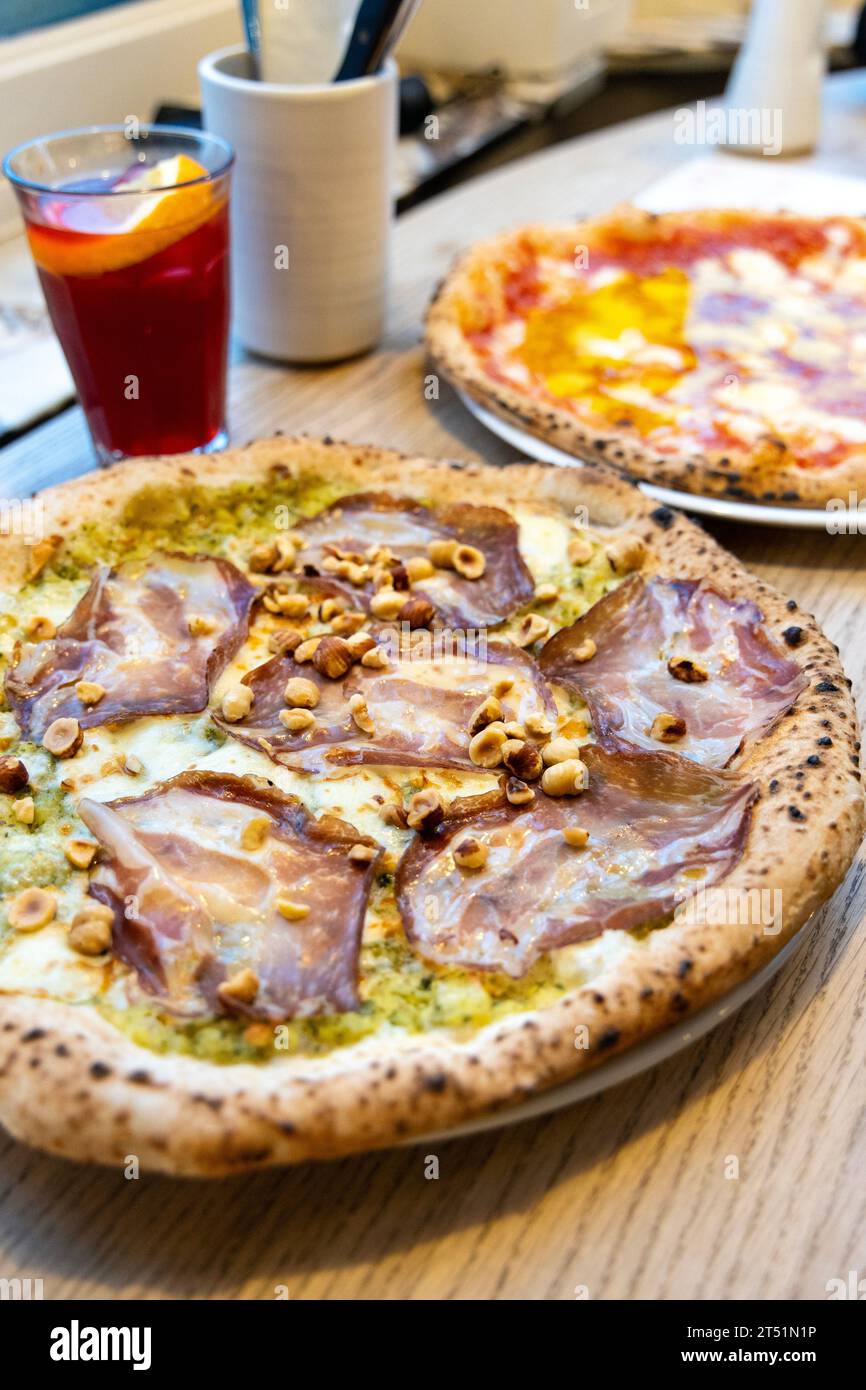 Cream of courgette base pizza with coppa ham and hazelnuts at NONA Merode, Brussels, Belgium Stock Photo