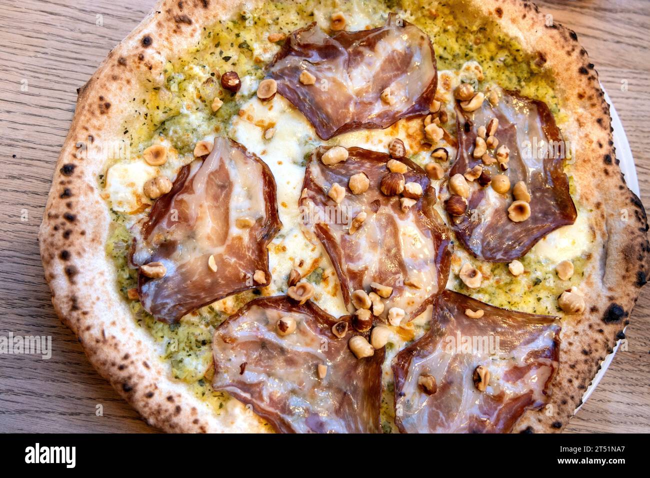 Cream of courgette base pizza with coppa ham and hazelnuts at NONA Merode, Brussels, Belgium Stock Photo