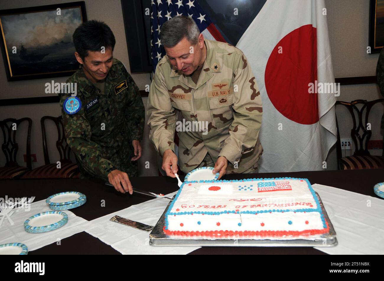 1001196832D-395  MANAMA, Bahrain (Jan. 19, 2010) Rear Adm. T. C. Cropper, deputy commander of U.S. Central Command and Japan Maritime Self-Defense Force Cmdr. Eiji Imanishi prepare to cut the cake at a ceremony marking the 50th anniversary of the Treaty of Mutual Cooperation and Security between the U.S. and Japan. Signed and ratified in 1960, the treaty serves as a foundation for the strong alliance and interoperability between the U.S. Navy and the Japan Maritime Self-Defense Force. Navy Stock Photo