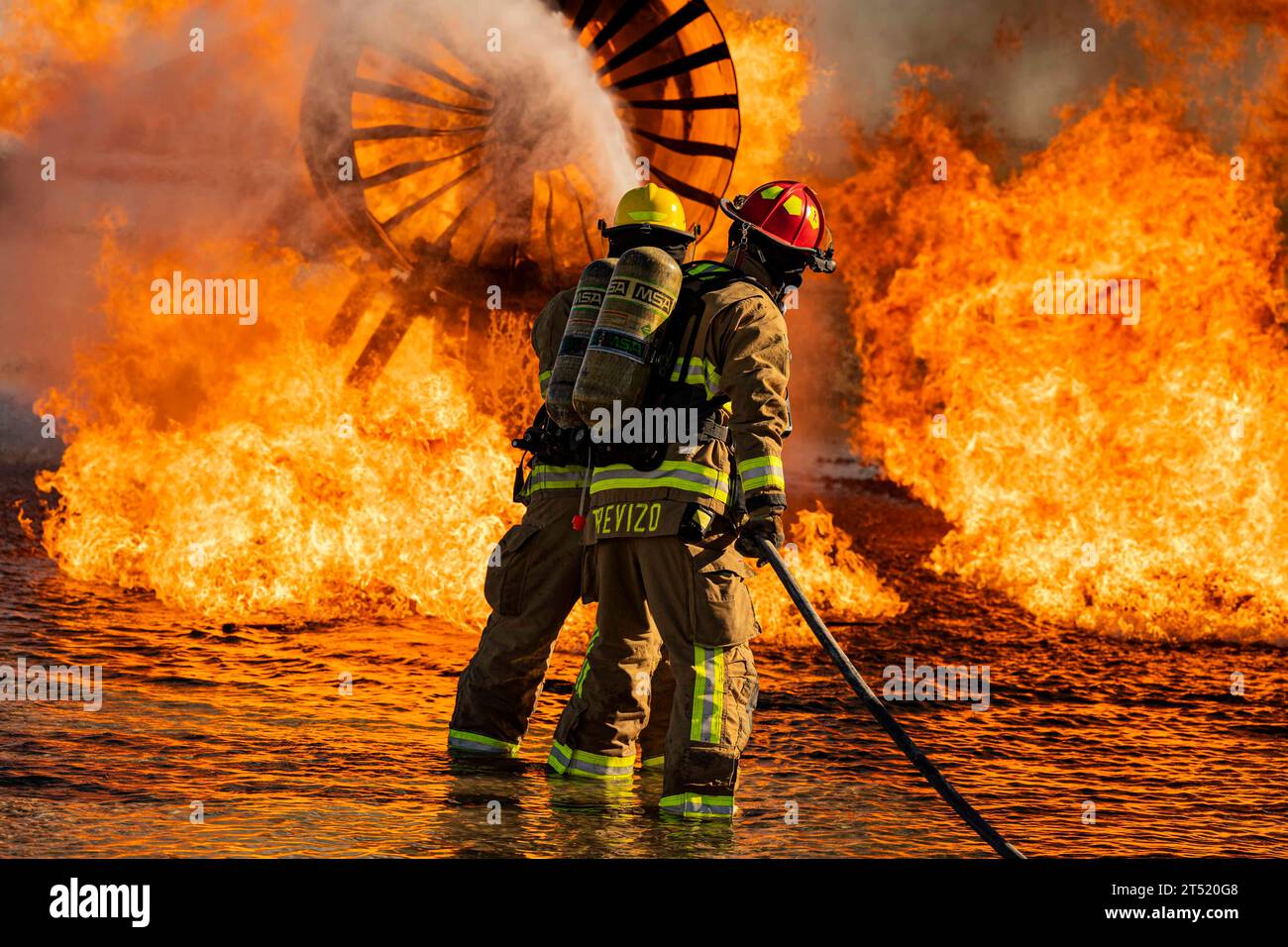October 12, 2023 - Nellis Air Force Base, Nevada, USA - Airman 1st Class Kyle Datu and Staff Sgt. Matt Trevizo, 99th Civil Engineering Squadron fire protection specialists, extinguish a fire during an aircraft live fire training exercise at Nellis Air Force Base, Nev., Oct. 12, 2023. Propane ignitors are built in multiple positions throughout and around the training fuselage, providing firefighters with a realistic training environment. (Credit Image: © Zachary Rufus/U.S. Air Force/ZUMA Press Wire) EDITORIAL USAGE ONLY! Not for Commercial USAGE! Stock Photo