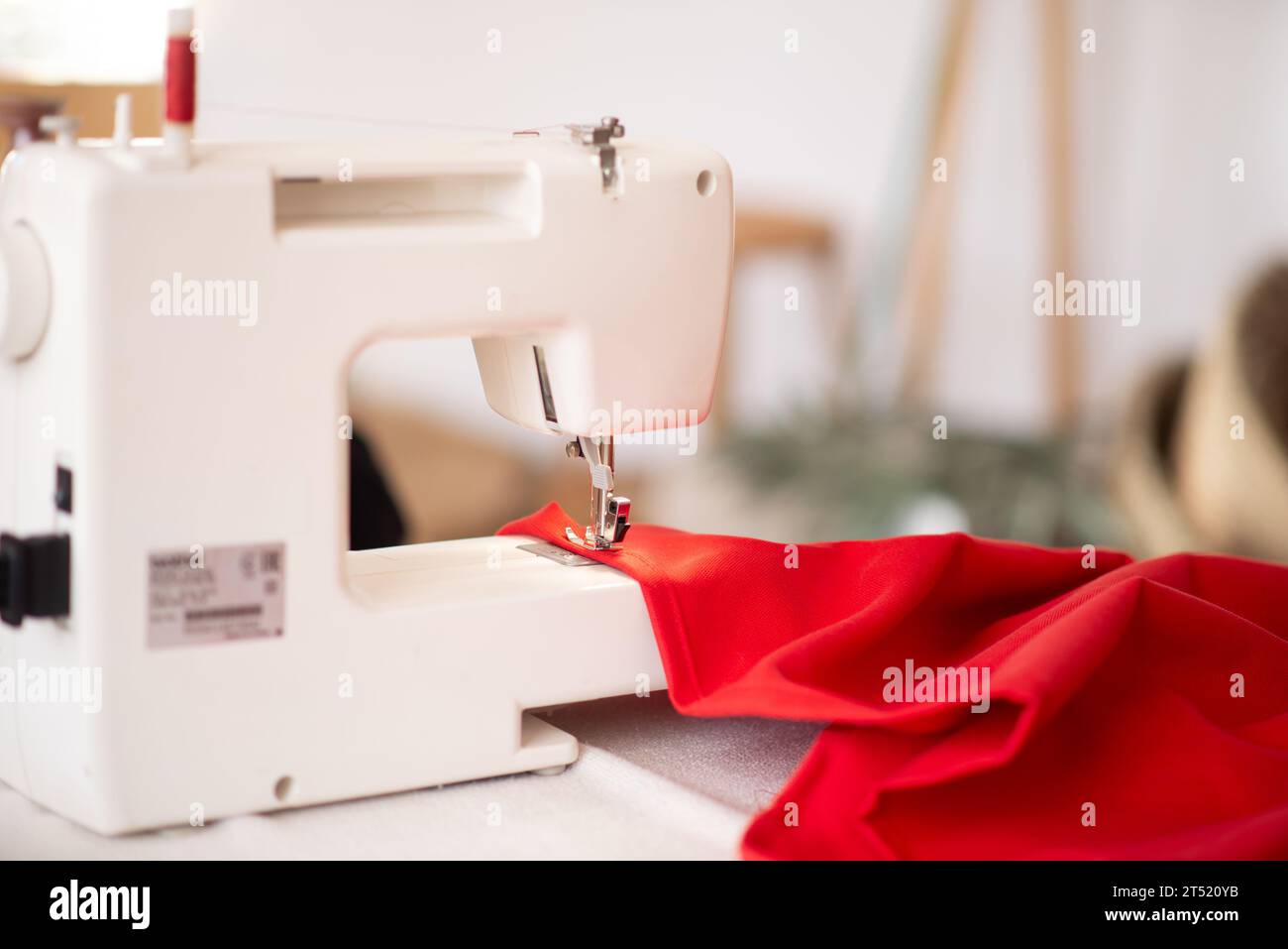 Sewing machine with red cloth closeup. sewing process in the re ...
