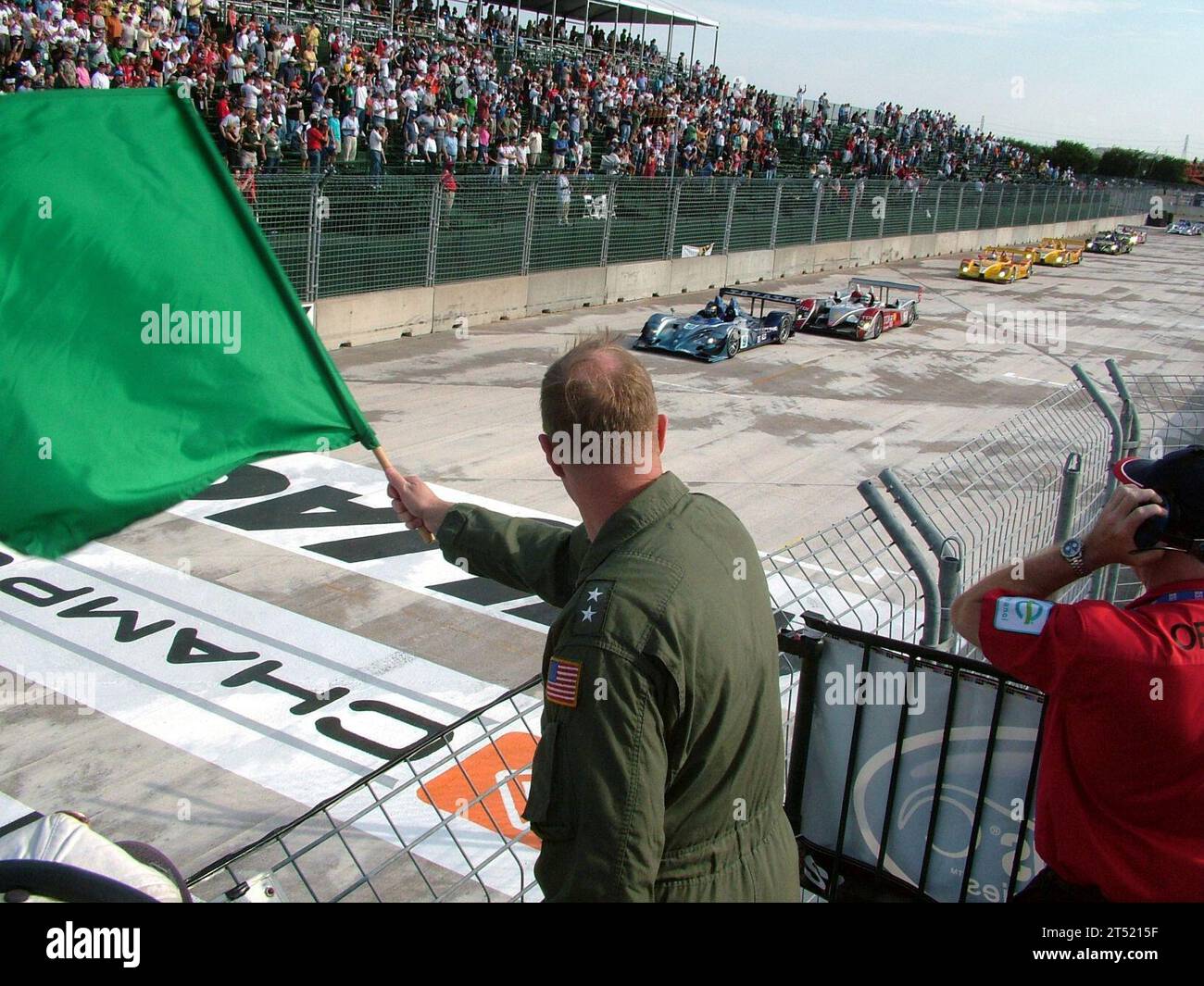 0704217665S-074 HOUSTON, Texas (April 21, 2007) Р Commander, Naval Strike and Air Warfare Center, Rear Adm. Mark T. Emerson, waves the green flag to signal the start of the American Le Mans Series sport car race at Houston. The American Le Mans Series is a series of North American professional sports car races. U.S. Navy Stock Photo