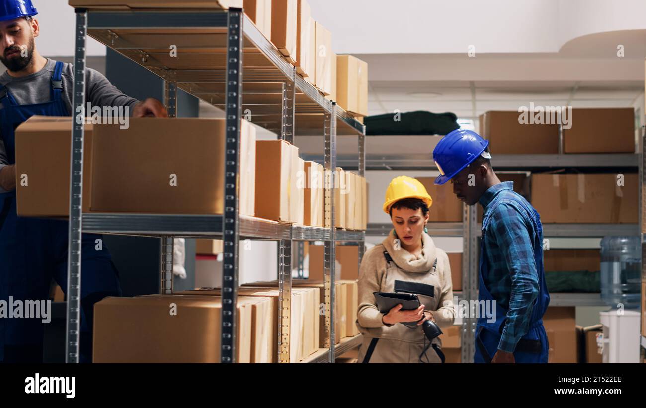 Diverse depot workers using digital tablet to scan goods, pointing ...