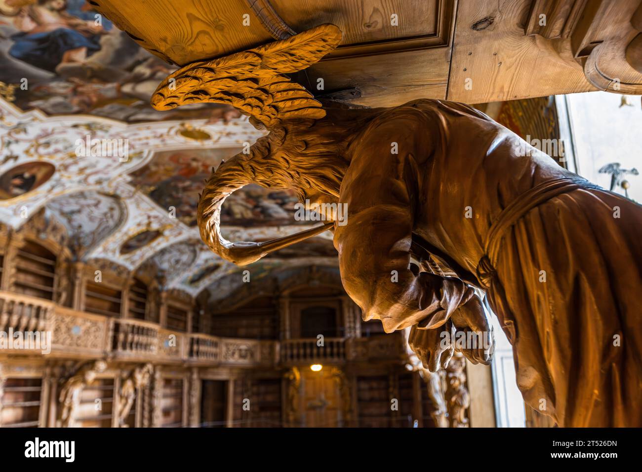 Carved, life-size wooden figure by the artist Karl Stilp in the library of Waldsassen Abbey. Shelves and carvings in the Waldsassen Abbey Library are made of lime wood. Waldsassen, Germany Stock Photo