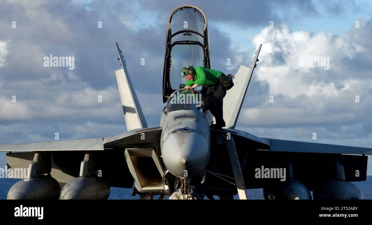 110530TU221-466 PACIFIC OCEAN (May 30, 2011) A Sailor steps into the cockpit of an F/A-18F Super Hornet assigned to Strike Fighter Squadron (VFA) 22 aboard the Nimitz-class aircraft carrier USS Carl Vinson (CVN 70). Carl Vinson and Carrier Air Wing (CVW) 17 are underway in the U.S. 7th Fleet area of responsibility. Navy Stock Photo