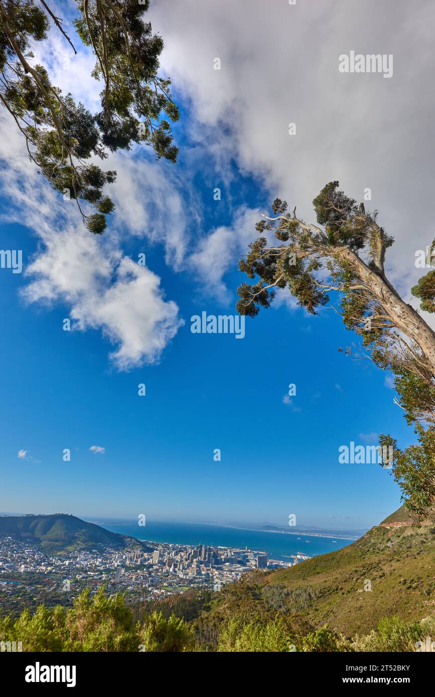 Beautiful scenic view of a coastal city from a mountain peak with trees ...
