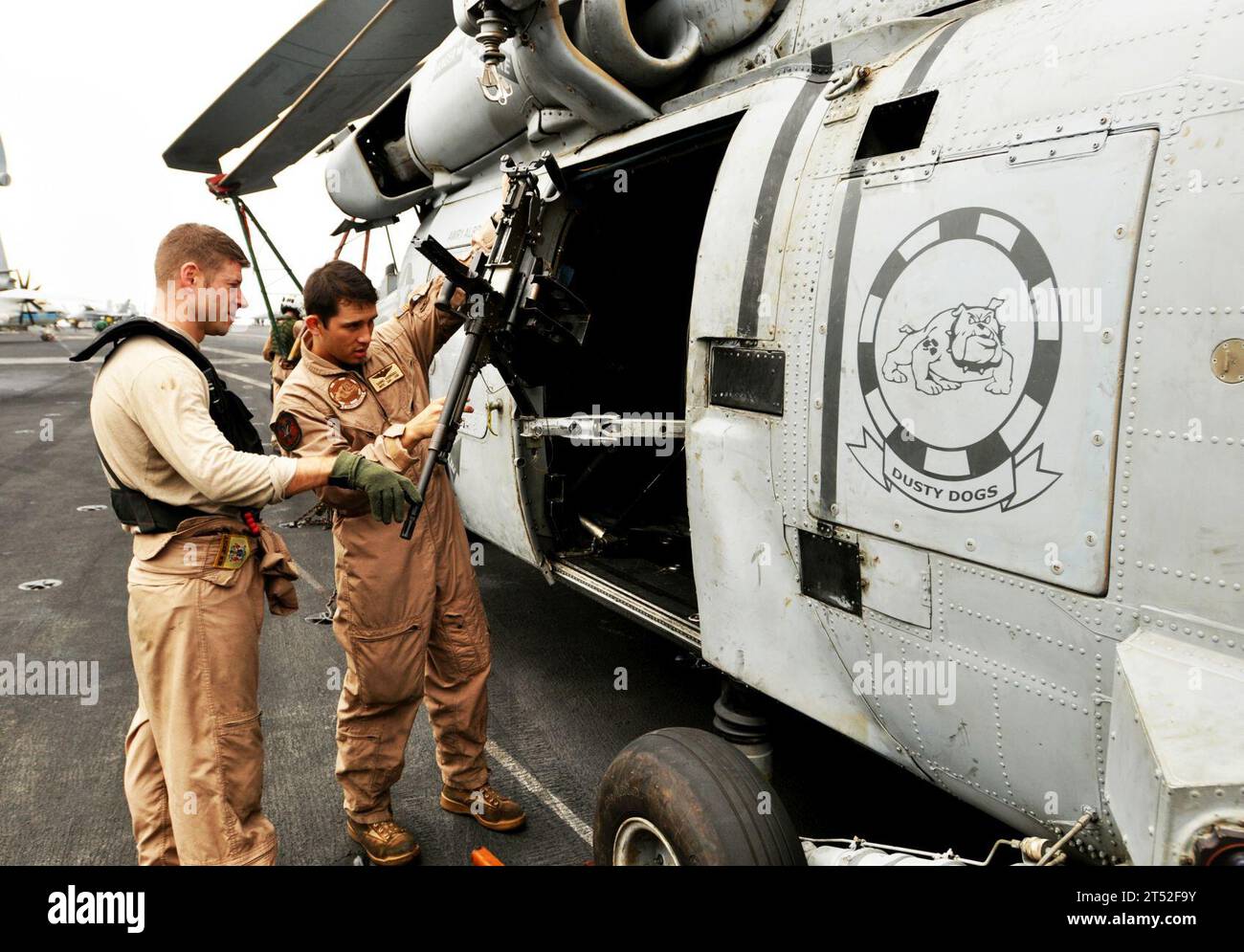 1007296003P-028  U.S. 5TH FLEET AREA OF RESPONSIBILITY (July 29, 2010) Naval Air Crewman 3rd Class Daniel Hersh, left, and Naval Air Crewman 2nd Class Gabriel Rodriguez, both assigned to the Dusty Dogs of Helicopter Anti-Submarine Squadron (HS) 7, perform a pre-flight check on an M-240B machine gun on the flight deck of the aircraft carrier USS Harry S. Truman (CVN 75). HS-7 is deployed as part of the Harry S. Truman Carrier Strike Group supporting maritime security operations and theater security cooperation efforts in the U.S. 5th Fleet area of responsibility. Navy Stock Photo