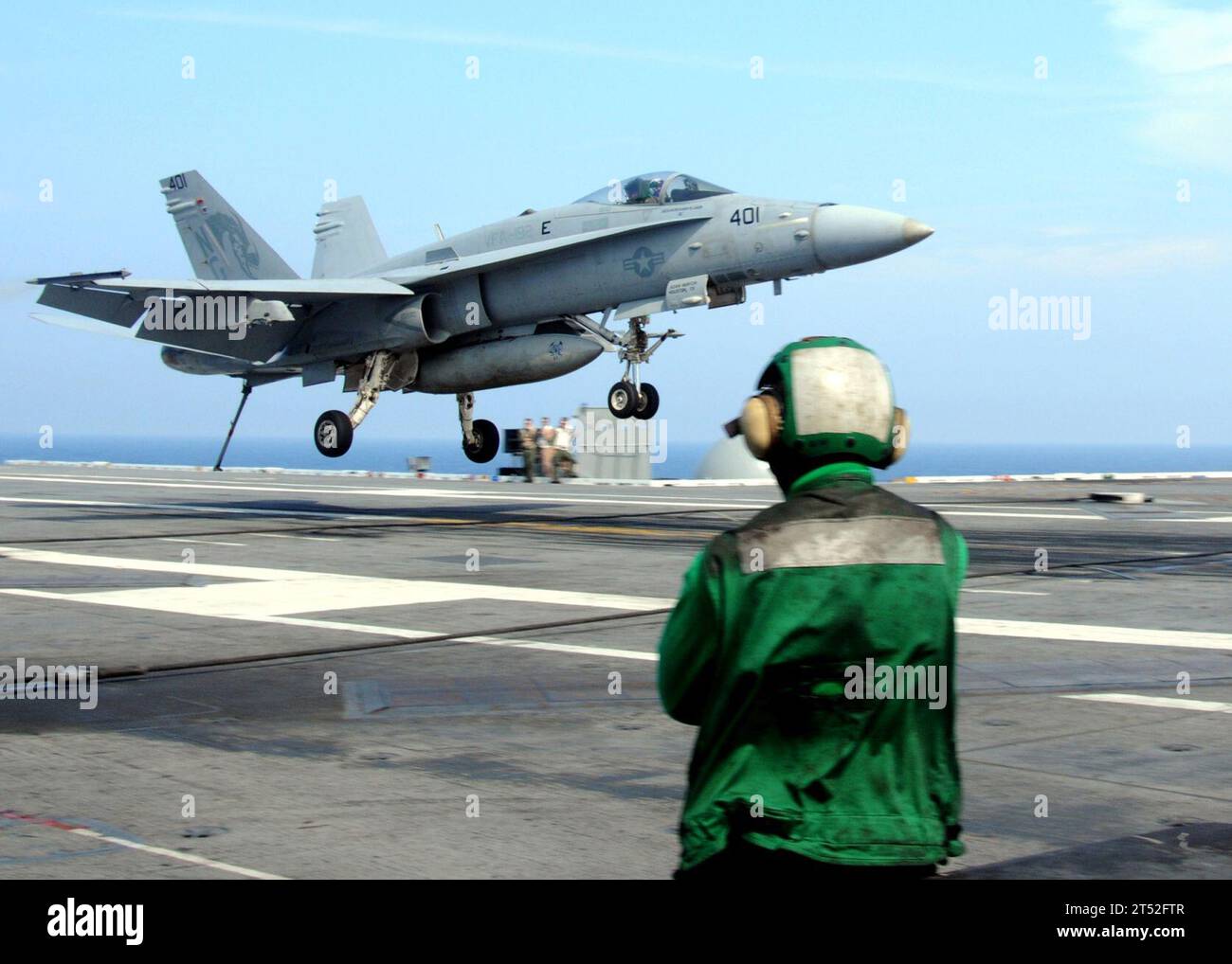 1007155446H-545 ATLANTIC OCEAN (July 15, 2010) A Sailor assigned to the aircraft carrier USS George H.W. Bush (CVN 77) watches as an F/A-18A Hornet assigned to the Golden Warriors of Strike Fighter Squadron (VFA) 87 lands on the flight deck. George H.W. Bush is conducting training in the Atlantic Ocean. (U.S. Navy Stock Photo