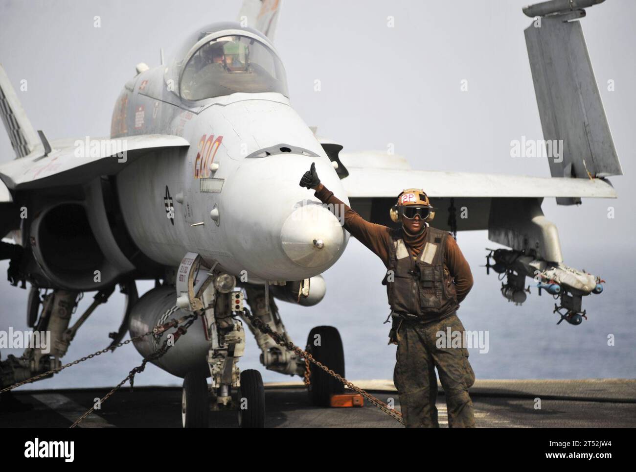 1007046003P-077 U.S. 5TH FLEET AREA OF RESPONSIBILITY (July 4, 2010) A plane captain assigned to the Checkerboards of Marine Fighter Attack Squadron (VMFA) 312 gives a thumbs-up to signal that the F/A-18C Hornet is ready to be moved to the catapult for take-off aboard the aircraft carrier USS Harry S. Truman (CVN 75). VMFA-312 is deployed as part of the Harry S. Truman Carrier Strike Group supporting maritime security operations and theater security cooperation efforts in the U.S. 5th Fleet area of responsibility. Navy Stock Photo