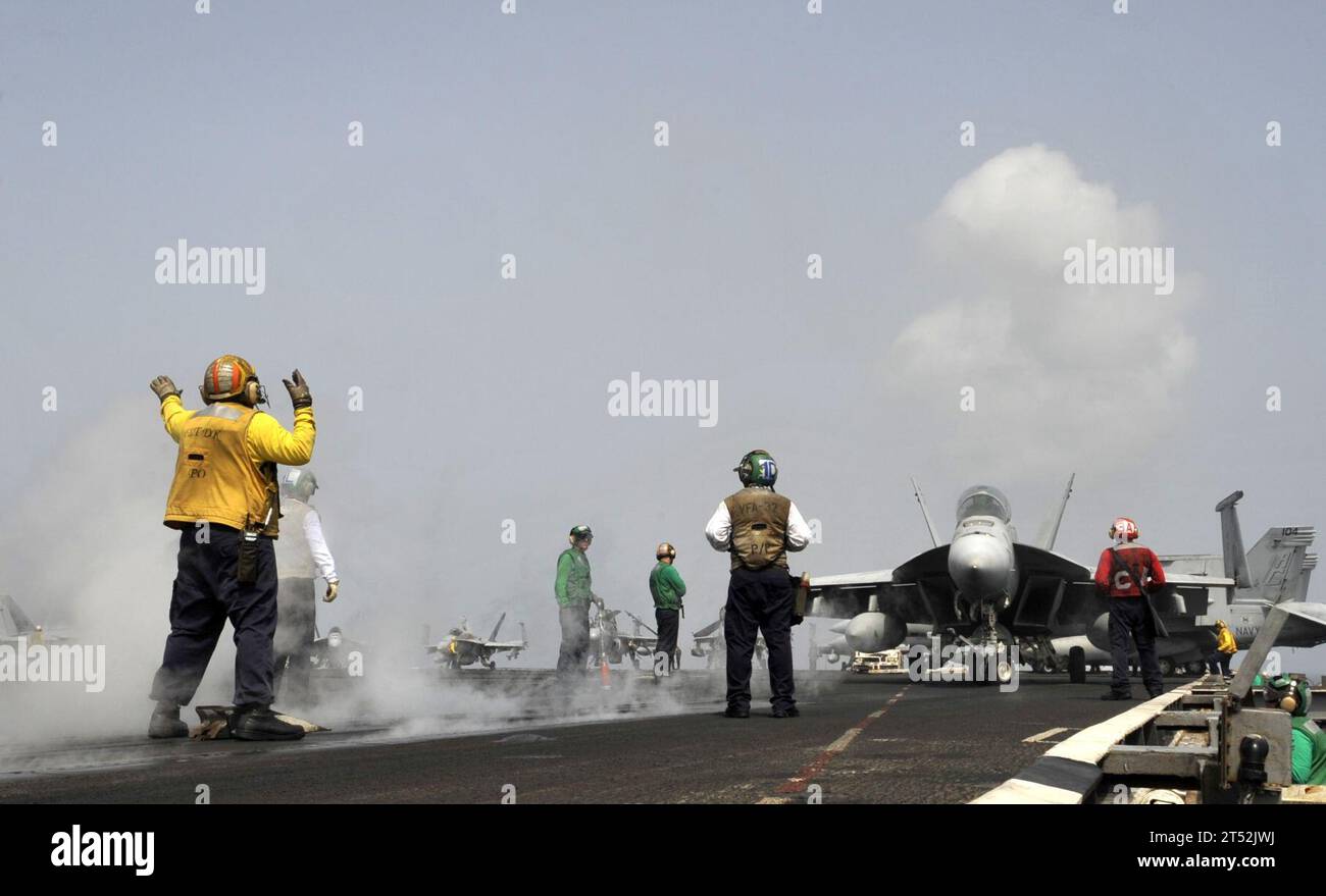 1007046003P-032 U.S. 5TH FLEET AREA OF RESPONSIBILITY (July 4, 2010) A plane director guides an F/A-18 Hornet onto the catapult for take-off aboard the aircraft carrier USS Harry S. Truman (CVN 75). Harry S. Truman is deployed as part of the Harry S. Truman Carrier Strike Group supporting maritime security operations and theater security cooperation efforts in the U.S. 5th Fleet area of responsibility. Navy Stock Photo
