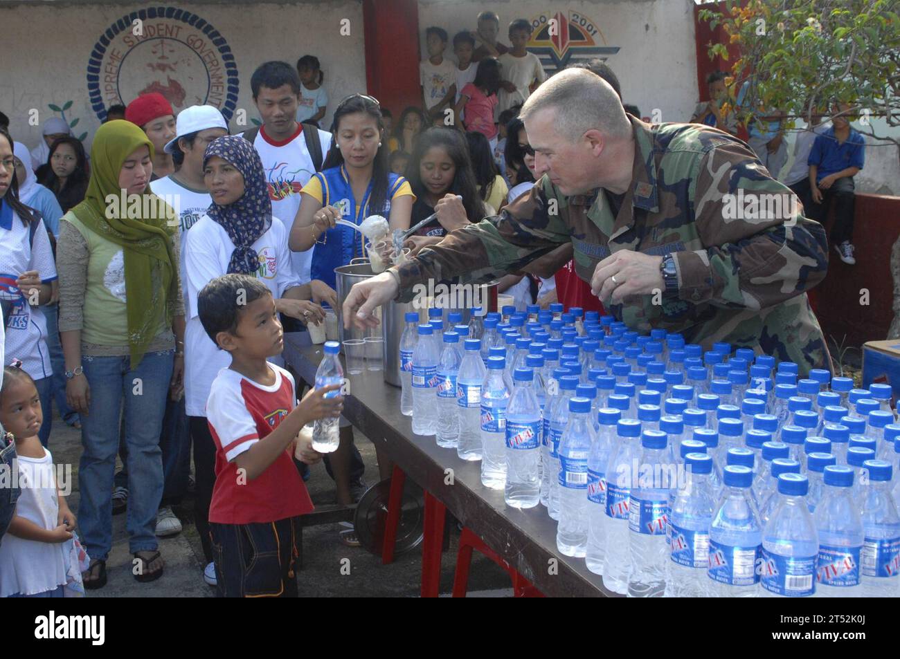 0712157286M-033 ZAMBOANGA CITY, Philippines (Dec. 15, 2007) U.S. Air Force Chaplin, Maj. Philip G. Houser hands out water to the children at MEIN College. Sailors, Airmen and Soldiers assigned to Joint Special Operations Task Force-Philippines (JSOTF-P) assisted MEIN College, INC. and the Kiwanis Club of METRO Zamboanga in handing out presents for the Holidays at the as part of their annual community outreach program.  U.S. Navy Stock Photo