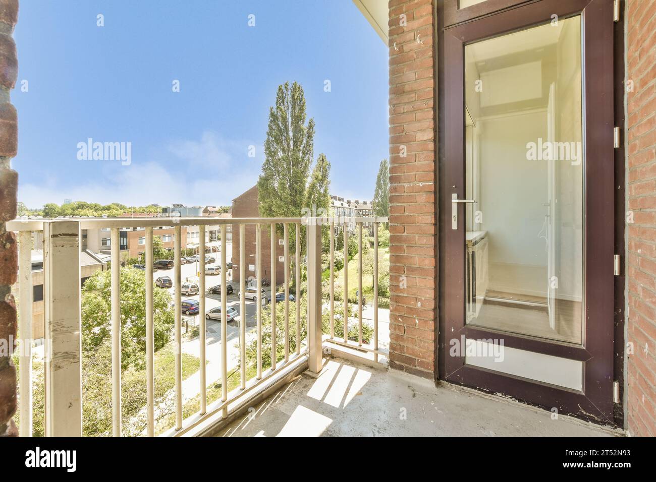 a balcony with an open door and cars parked on the street in the ...
