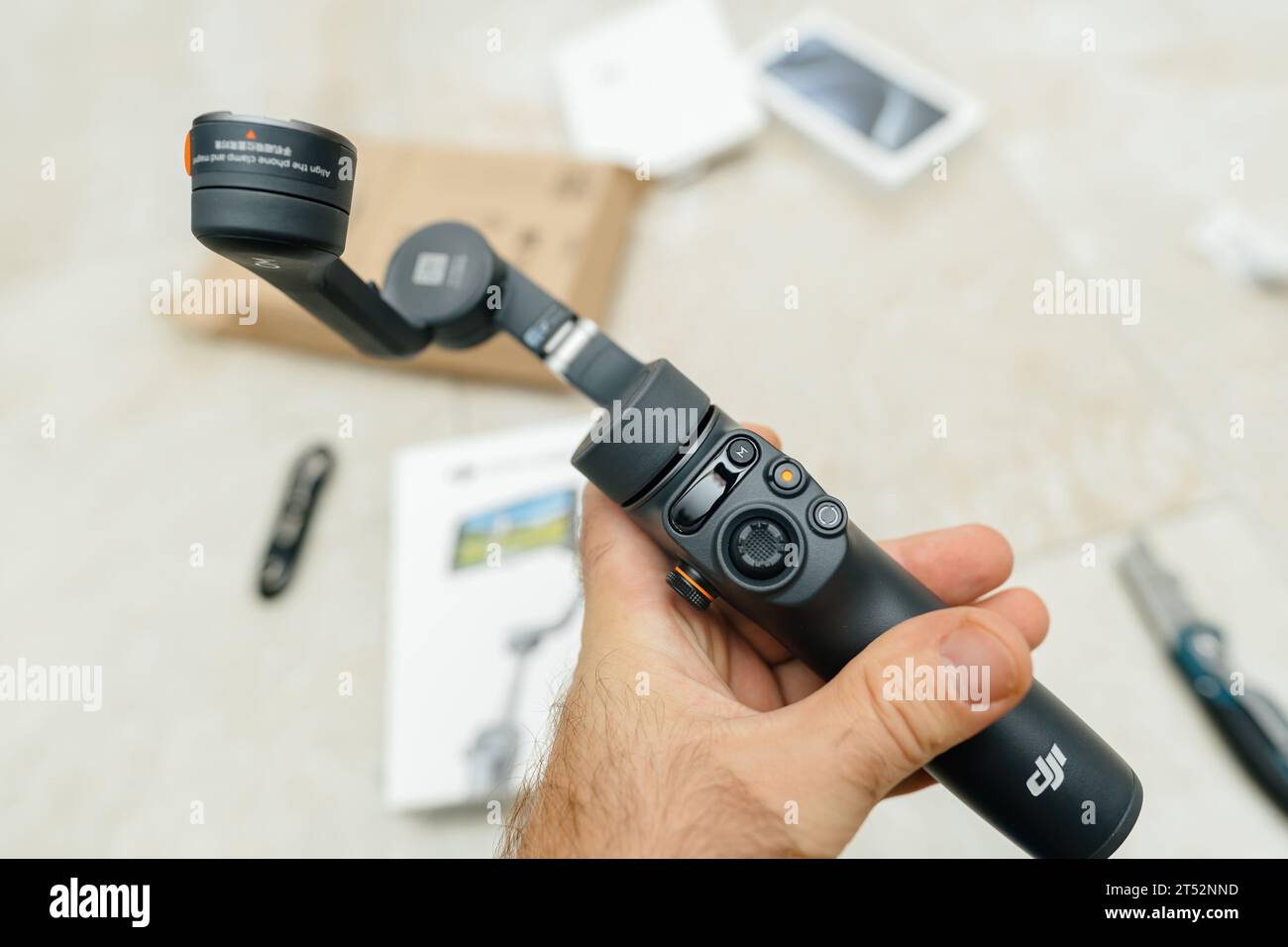 Paris, France - Oct 24, 2023: A male hand confidently holds the newest professional Osmo Mobile 6 gimbal, boasting features like ActiveTrack 5.0, a control ring, in a lightweight design Stock Photo