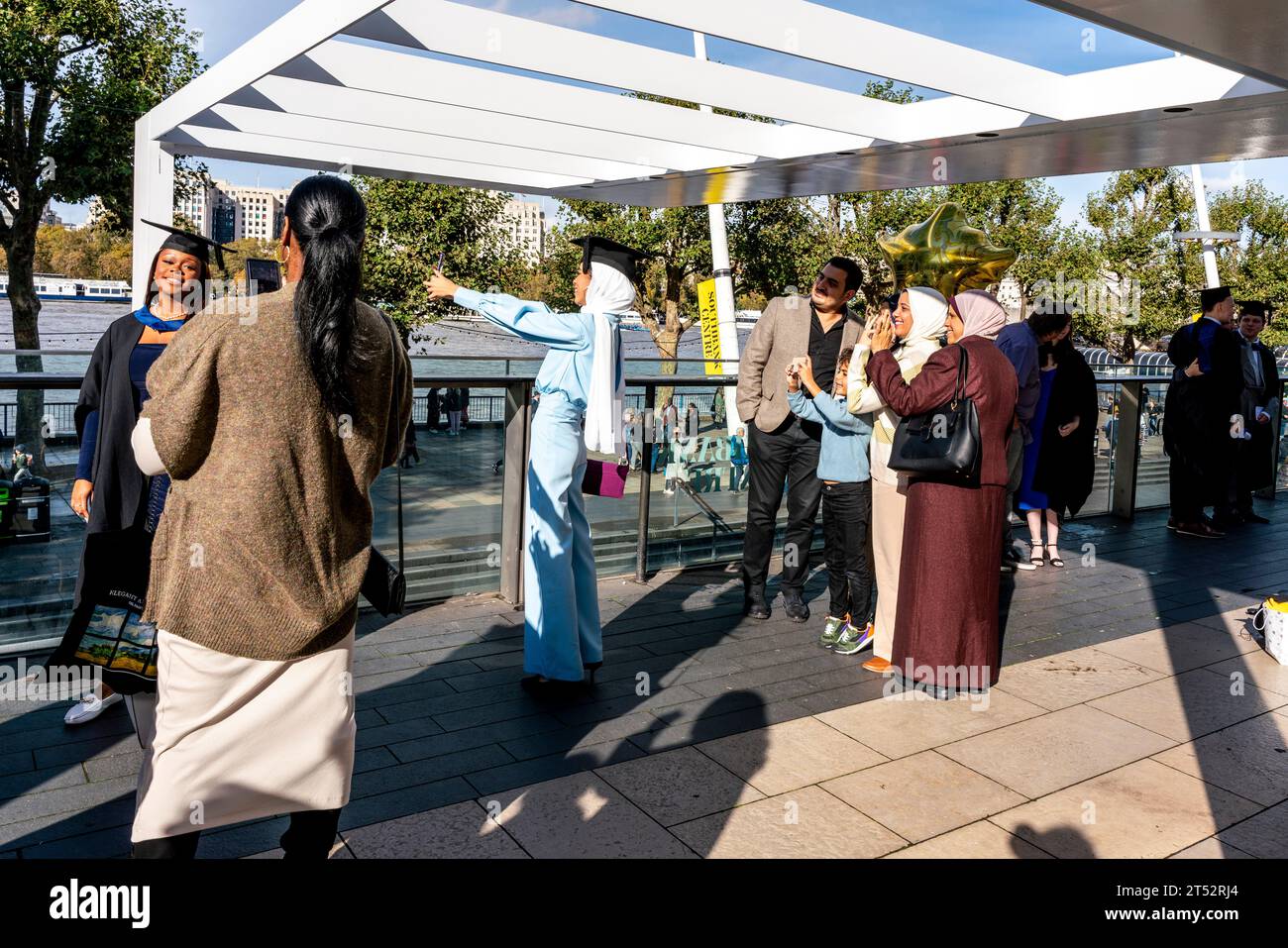 A Muslim Degree Student Poses For A Selfie With Her Family At Her Graduation Ceremony, The Southbank, London, UK. Stock Photo