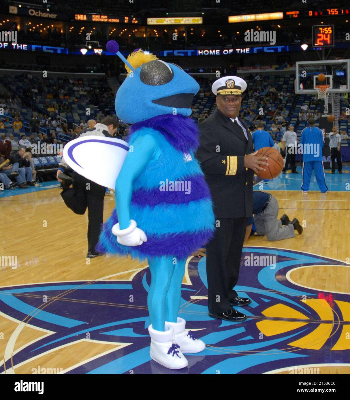 0911049319B-099 NEW ORLEANS (Nov. 4, 2009) Rear Adm. Victor G. Guillory, commander of U.S. Naval Forces Southern Command/U.S. 4th Fleet watches the mascot for the New Orleans Hornets stand at attention during Navy Night at the New Orleans Arena. Guillory is a native of New Orleans. Navy Night was one of several New Orleans Navy Week events. Navy Weeks are designed to show Americans the investment they have made in their Navy and increase awareness in cities that do not have a significant Navy presence. Stock Photo