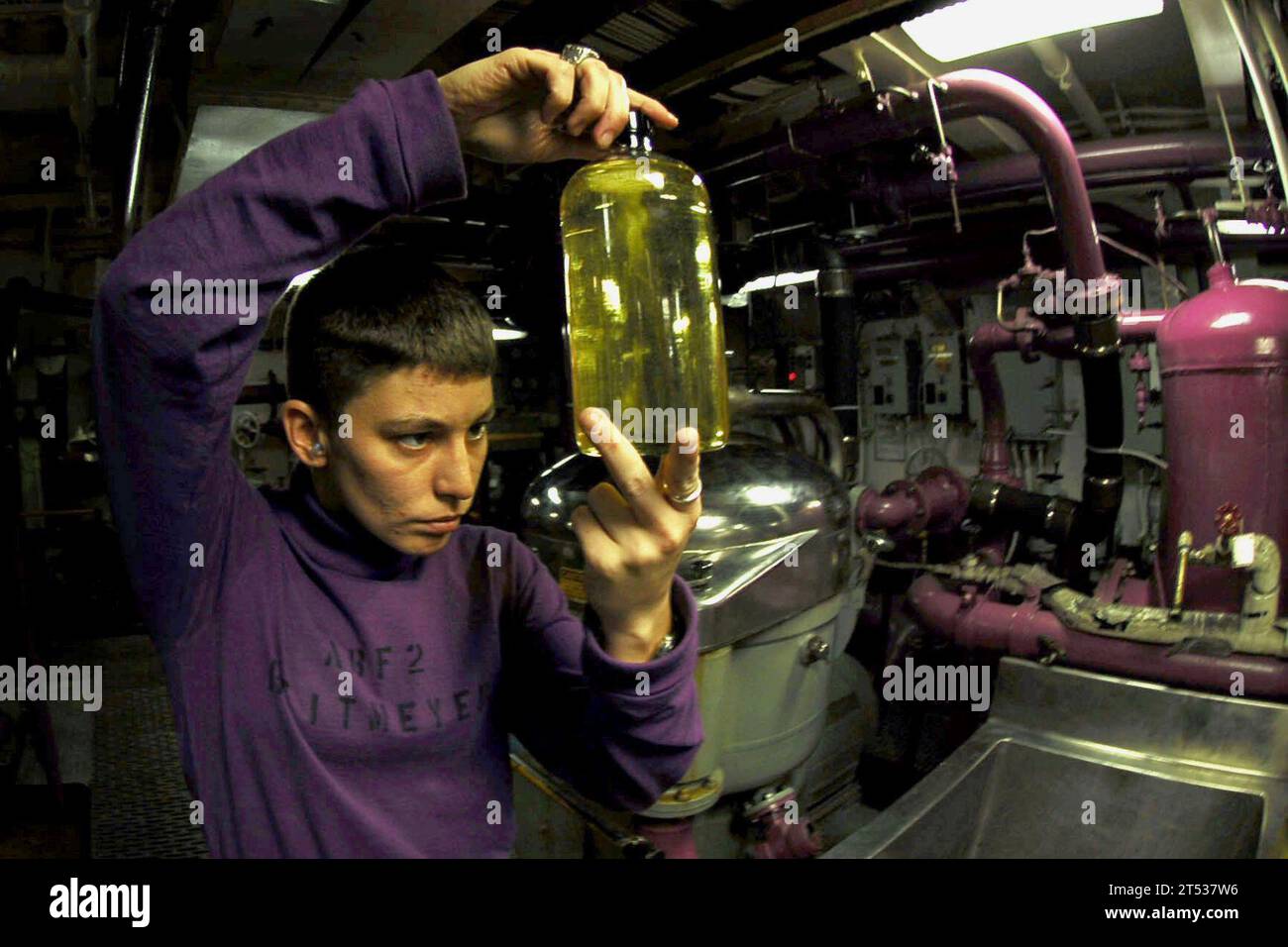 below decks, fuel, inspect, interior, purple shirt Stock Photo