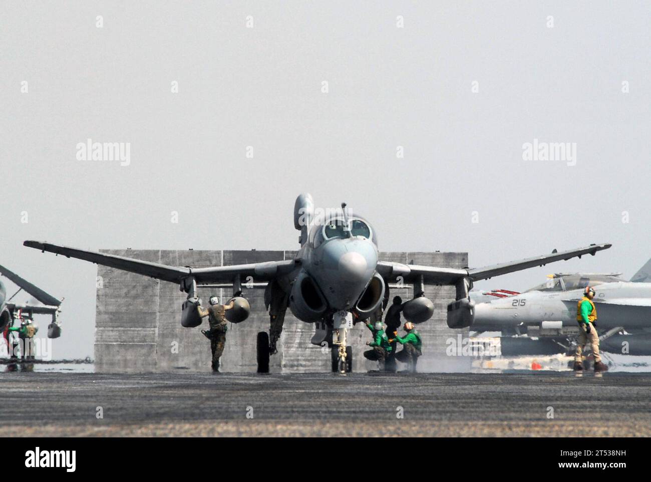 0707208119R-083 PERSIAN GULF (July 20, 2007) - An EA-6B Prowler, assigned to the ТBlack RavensУ of Tactical Electronic Warfare Squadron (VAQ) 135, lowers its wings while Sailors do last minute safety checks before launch aboard nuclear-powered aircraft carrier USS Nimitz (CVN 68). Nimitz Strike Group and embarked Carrier Air Wing (CVW) 11 are deployed in the 5th Fleet area of operations conducting maritime operations and supporting the global war on terrorism. U.S. Navy Stock Photo
