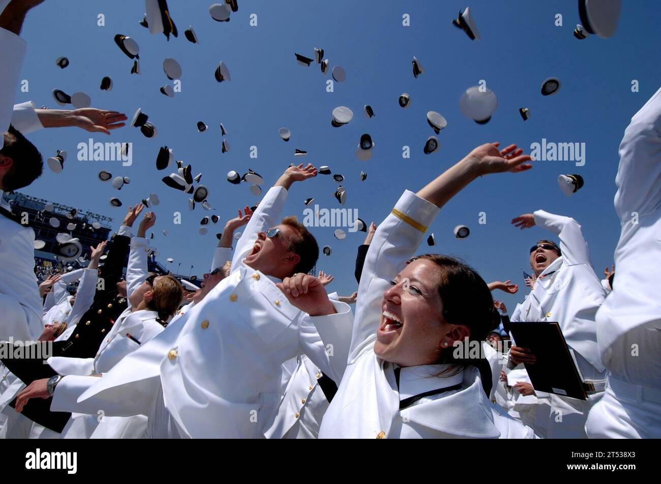 0705253642E-725  ANNAPOLIS, Md. (May 25, 2007) - Ens. Morgan Kitchen, lower-right, a newly commissioned U.S. Naval Officer celebrates her new rank with the traditional tossing of the Midshipmen cover during the U.S. Naval Academy class of 2007 Graduation and Commissioning Ceremony at Annapolis, Md. The 'hat toss,' originated at the Naval Academy in 1912, and has since become a symbolic and visual end to the four-year program. One Thousand twenty-eight Midshipmen graduated from the U.S. Naval Academy and became commissioned officers in the U.S. Military. U.S. Navy Stock Photo