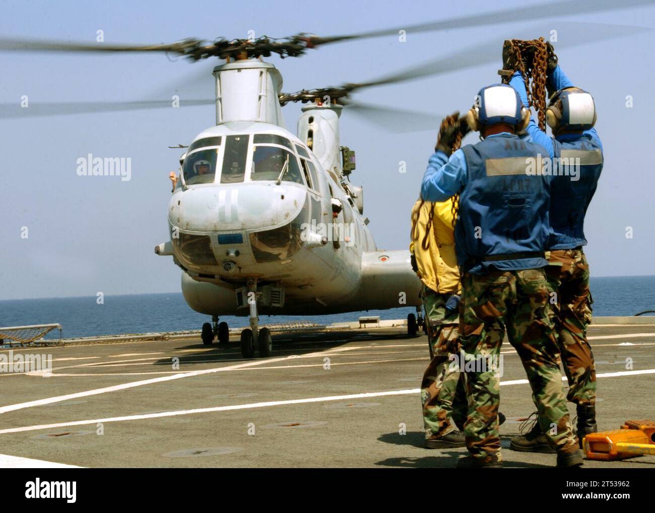 0910243925A-001 JAVA SEA (Oct. 24, 2009) Sailors aboard the amphibious transport dock ship USS Cleveland (LPD 7) signal to the pilot of a CH-46 Sea Knight helicopter assigned to Marine Medium Helicopter Squadron (HMM) 166 that the chock and chains have been removed and the aircraft is ready for flight. Cleveland is part of the Bonhomme Richard Amphibious Ready Group and is transiting the U.S. 7th Fleet area of responsibility. Stock Photo