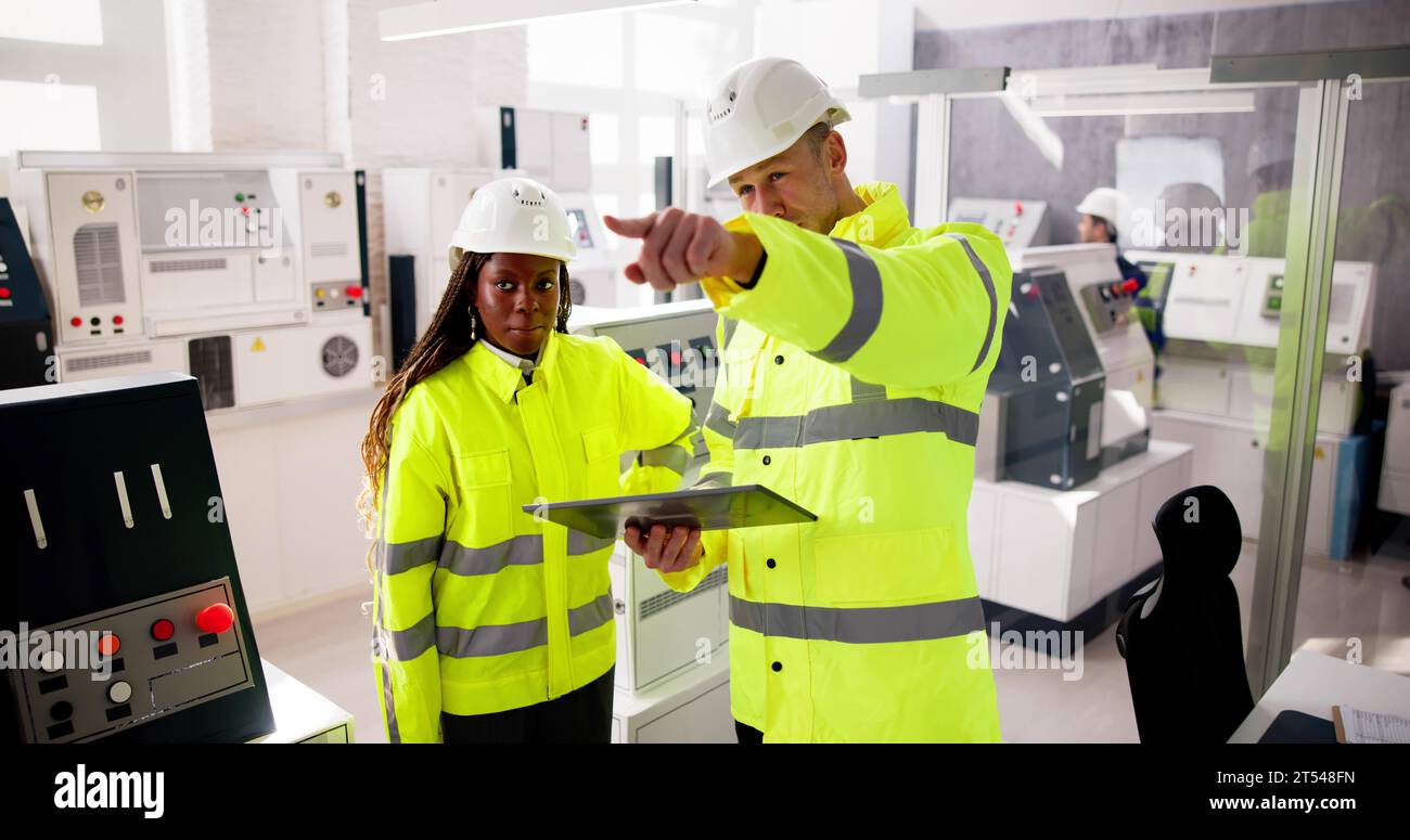 Factory Engineers In Helmets. Checking Industrial Facility Stock Photo