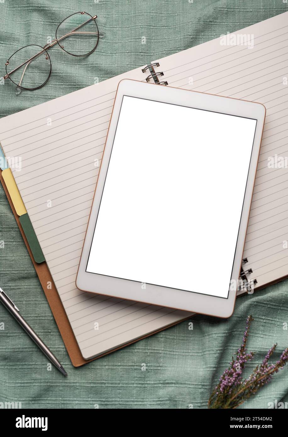Tablet empty white screen and notebooks  on the office desk Stock Photo