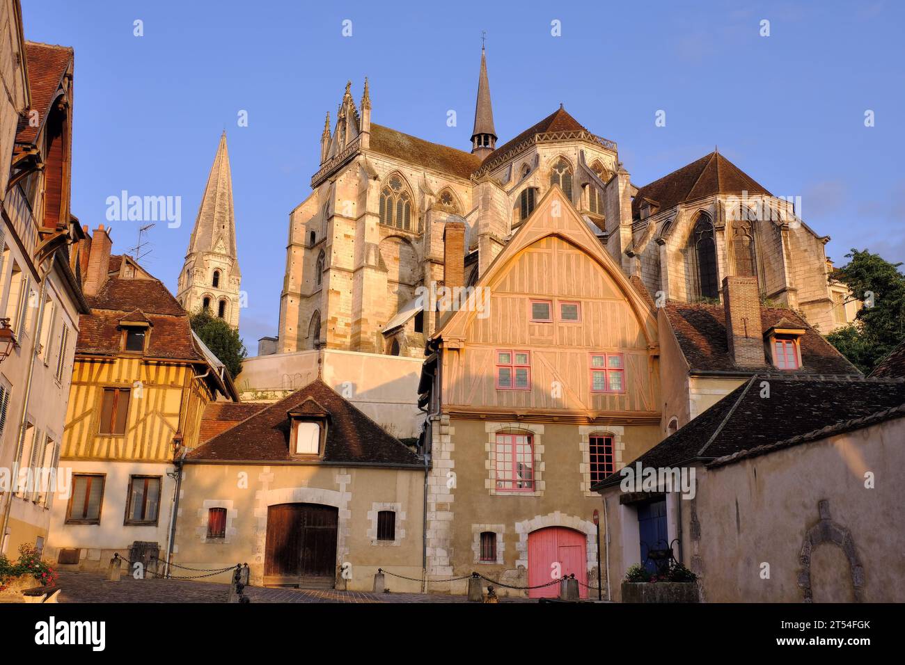 Auxerre: Abbey Saint-Germain and half timbered buildings glowing orange soon after sunrise in Place du Coche d’Eau, Auxerre, Burgundy Stock Photo