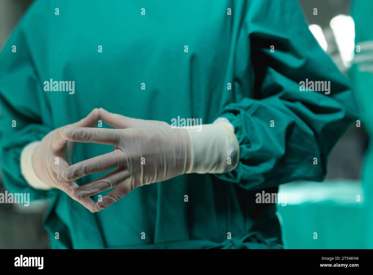 Midsection of asian female surgeon wearing surgical gown in operating theatre at hospital Stock Photo