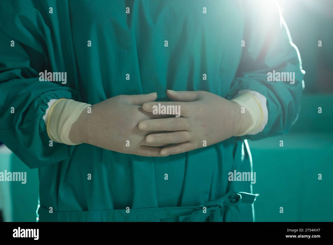 Midsection of asian female surgeon wearing surgical gown in operating theatre at hospital Stock Photo